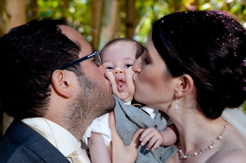 Bride and groom kissing baby's cheeks - photo by South Africa based wedding photographer Greg Lumley